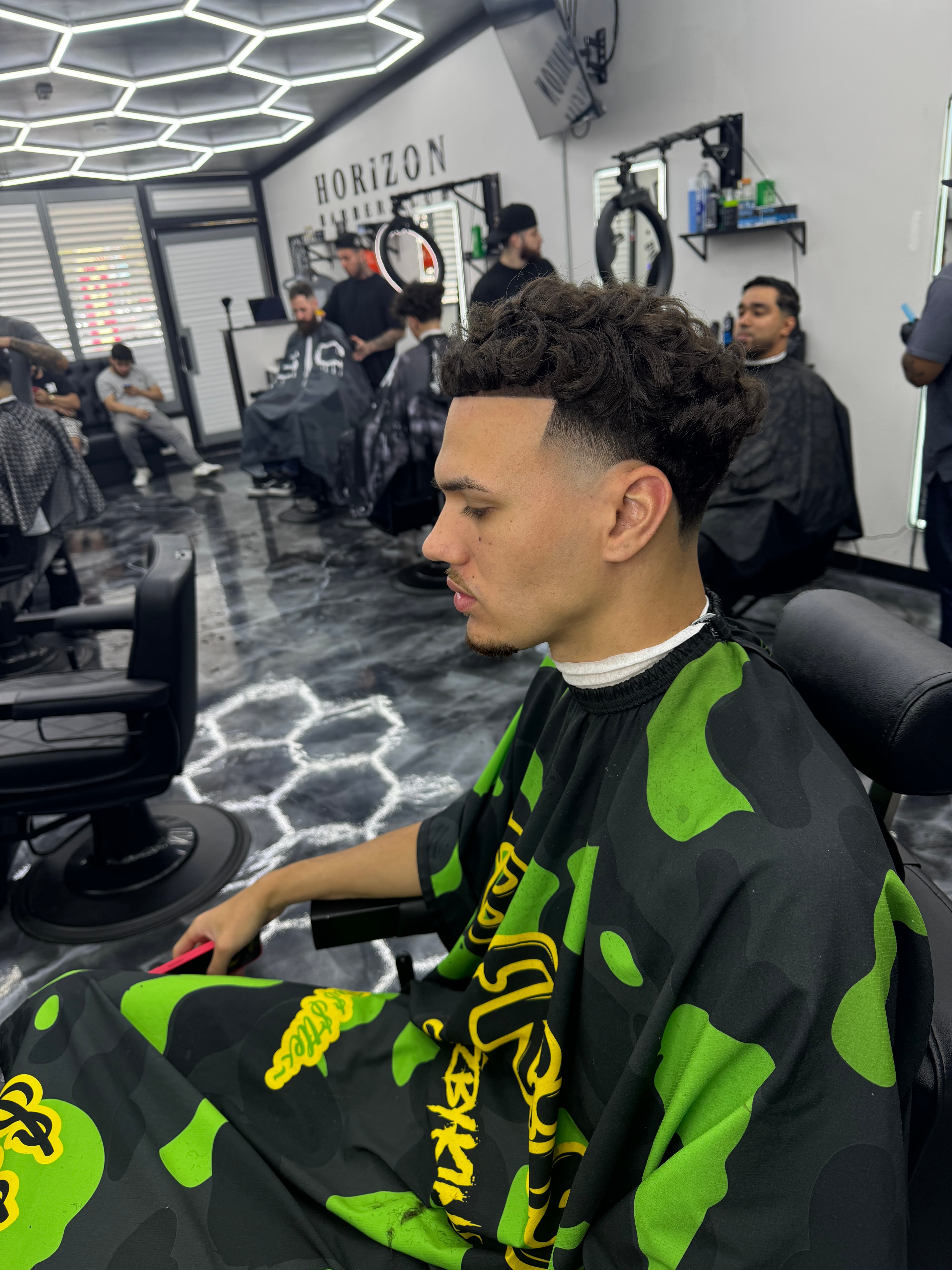 Barbershop scene with curly hair fade